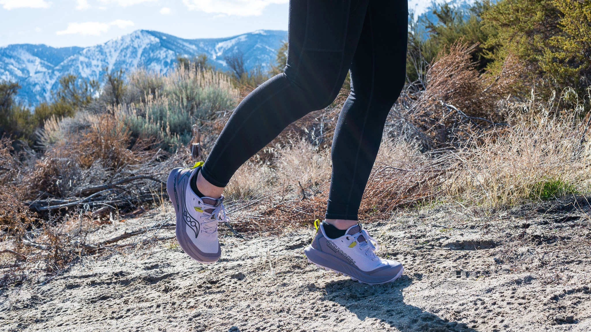 Close-up of the Saucony Peregrine 15 women's trail running shoe on a dirt trail.